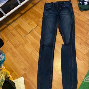 Dark blue jeans with rips in knees